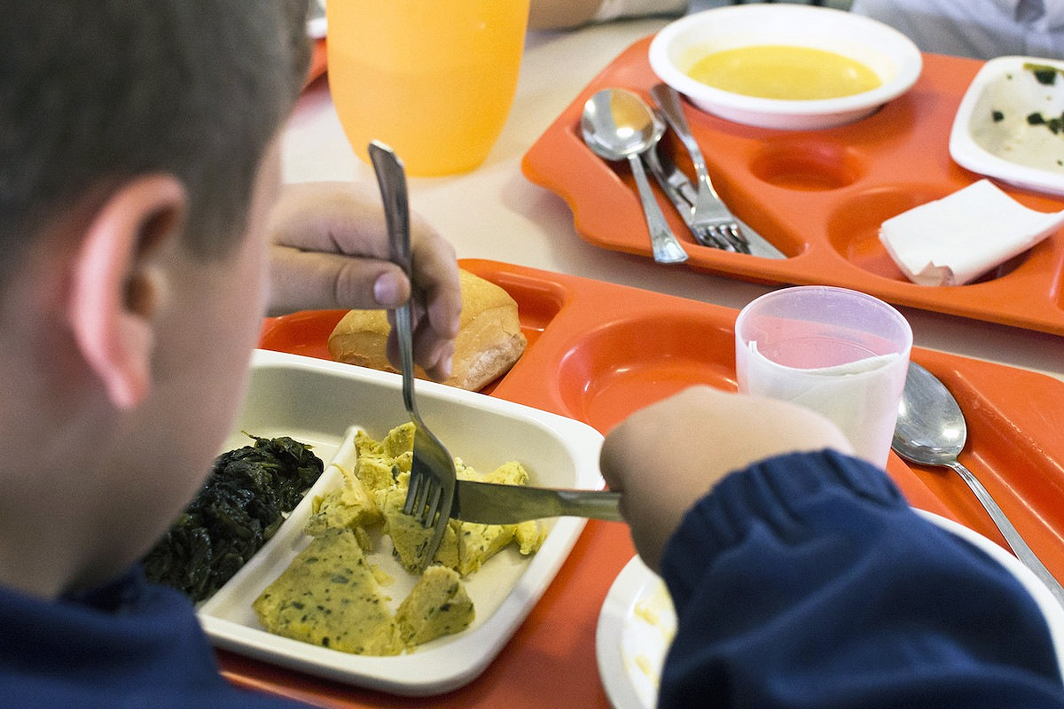 Immagine di un bambino che consuma un pasto nella mensa scolastica